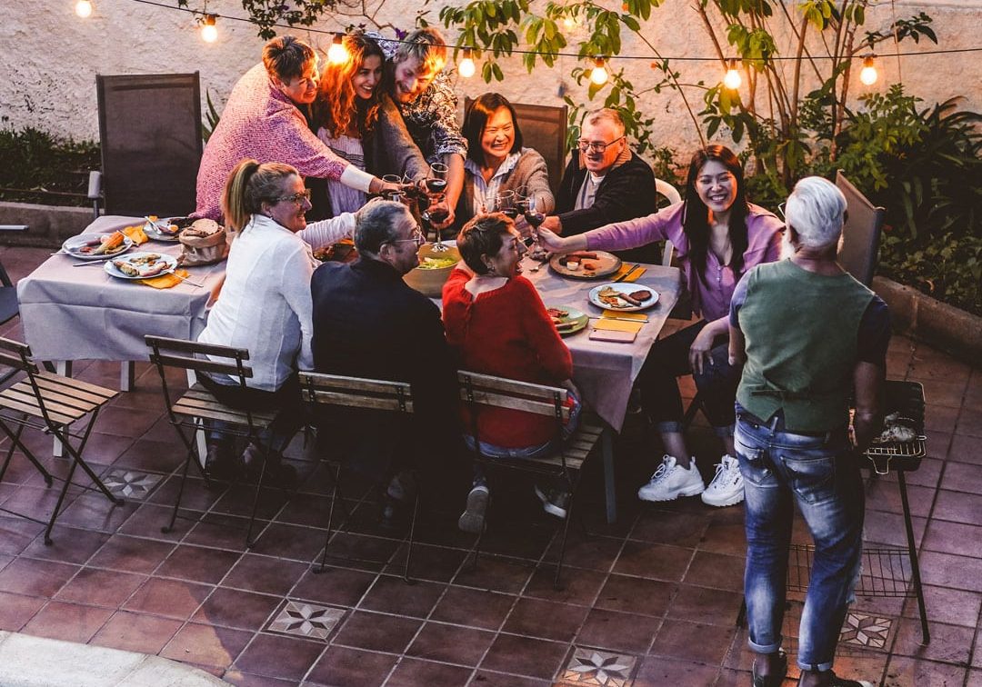 Group of friends having fun at an outdoor BBQ on a summer evening